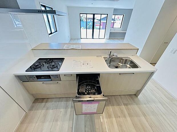 開放感のあるキッチンはリビングダイニングとつながる設計です。食洗機と3口コンロが備わり作業がしやすいレイアウトです。窓から自然光が入り明るい雰囲気を感じられます。