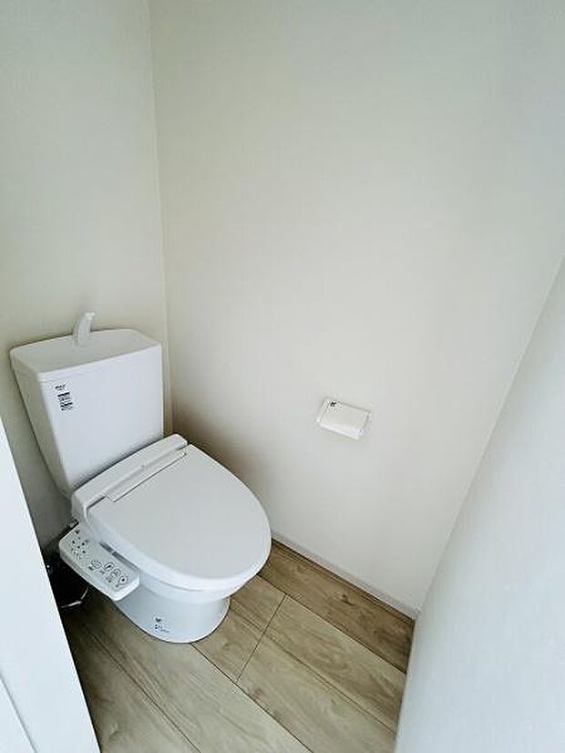 シンプルなデザインのトイレです。壁と床のコントラストが空間をすっきりと見せています。温水洗浄便座が設置されていますので快適にご利用いただけます。清潔感のある内装となっています。