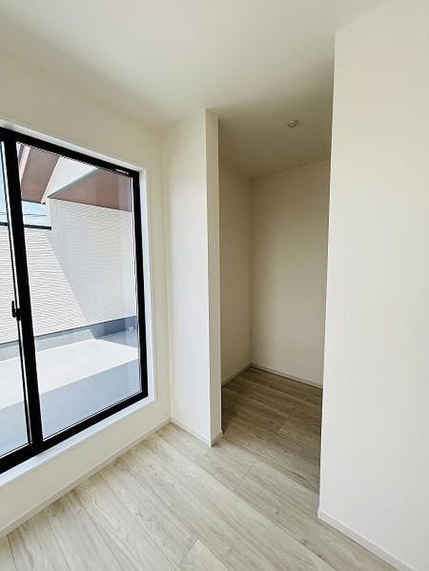 大きな窓から採光が入る明るい空間です。壁面はシンプルでお手入れもしやすい造りとなっています。収納スペースがしっかり確保されておりすっきりとした印象です。床材は落ち着いた色合いで統一感があります。
