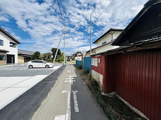 前面道路が広く車の出し入れもスムーズに行えます。周辺は落ち着いた住宅街で整備された街並みが印象的です。現地の雰囲気を感じることができる写真です。周囲の建物も新しく清潔感があります。