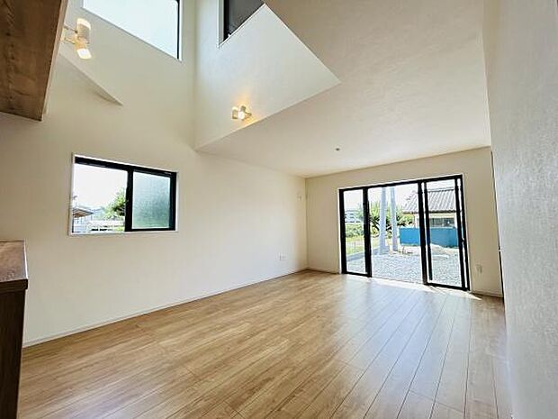 リビングの大きな窓から光がたっぷり入り開放感のある空間が広がっています。吹き抜け天井がアクセントになり室内をより明るく演出します。床材の質感も心地よくさまざまなインテリアに合わせやすい仕様です。