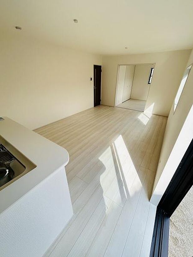 リビングは明るい床材が特徴的で室内全体が爽やかな印象です。大きな窓から自然光がたっぷり入ります。シンプルな配色でお好みに合わせて空間づくりが楽しめます。キッチンとのつながりも良好です。