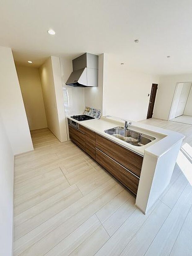 窓からの採光が明るいキッチンです。木目調のデザインが空間を引き締めます。収納スペースが豊富なので整理整頓もしやすいキッチンです。作業スペースにもゆとりがあります。