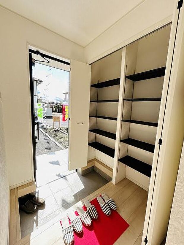 玄関には大容量の収納スペースが備わっており使い勝手の良い設計です。シューズラックが整然と配置されているためすっきりとした印象があります。明るい採光があり玄関まわりが開放的な雰囲気です。