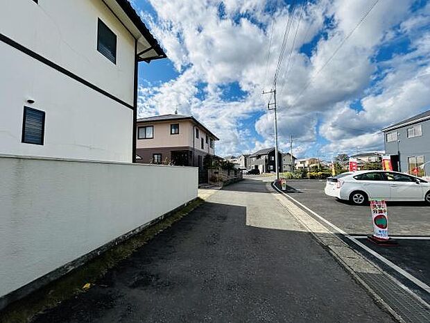 前面道路が広く車の出入りがしやすい印象です。現地周辺は住宅が立ち並び落ち着いた雰囲気が感じられます。道路沿いには電柱も整然と並んでおり街並みに調和しています。