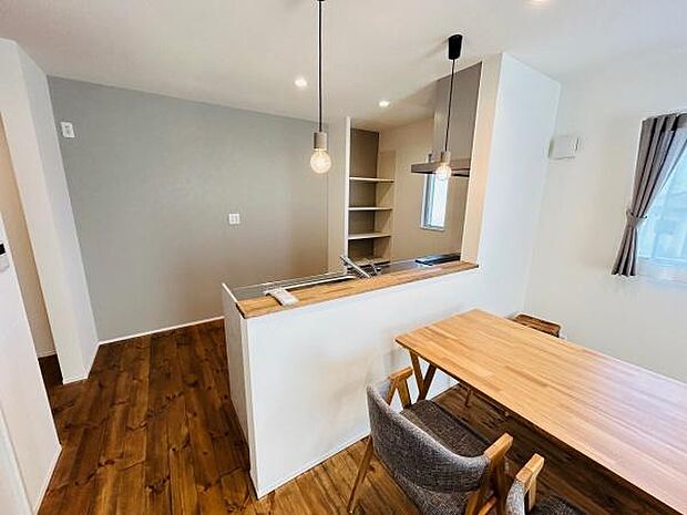 木目調のフローリングが温かみを感じさせるキッチン空間です。カウンターは使い勝手が良く食事の用意や作業にも便利です。シンプルなペンダントライトがポイントになっています。