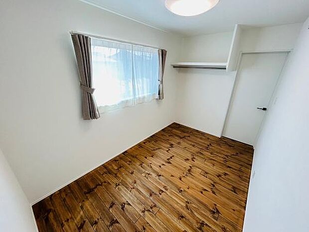 明るい窓から自然光が広がる子供部屋です。落ち着いた色合いの床材が特徴的です。シンプルな内装が部屋の広がりを感じさせます。収納スペースも設けてあり使い勝手の良い空間です。壁やカーテンは清潔感があります。