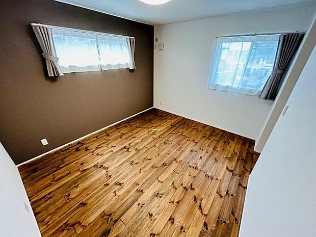 二面採光で明るさが感じられる洋室です。アクセントクロスが空間に落ち着きをプラスしています。フローリングの風合いが印象的です。シンプルな設計で家具の配置もしやすいです。清潔感のある室内となっています。