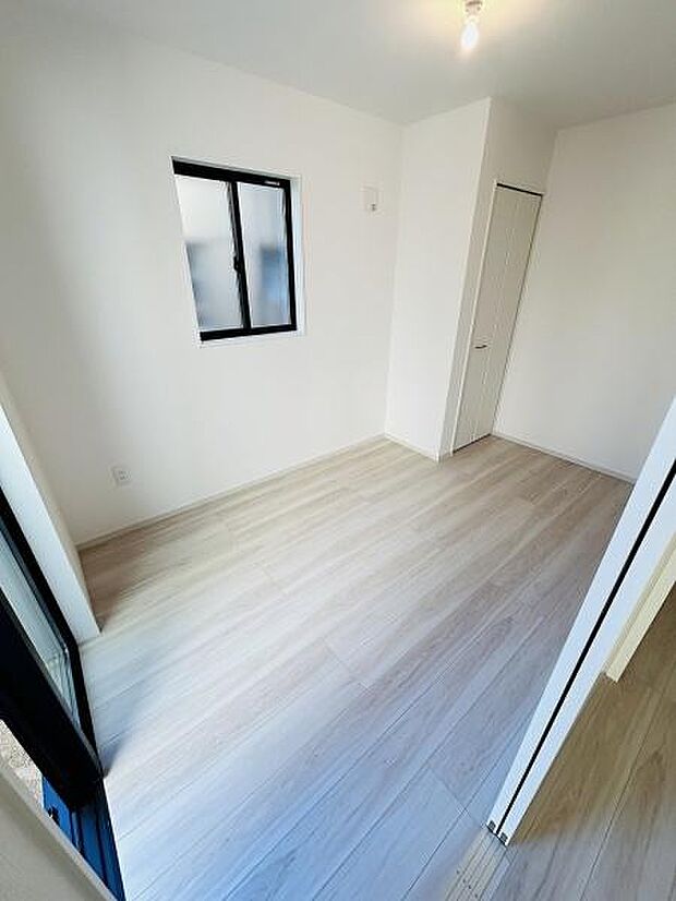 明るい色合いのフローリングが特徴の洋室です。二面に窓があり開放感のある空間が広がっています。壁や床がシンプルなため家具の配置がしやすい点も魅力です。収納スペースも確保されておりすっきりとした印象です。