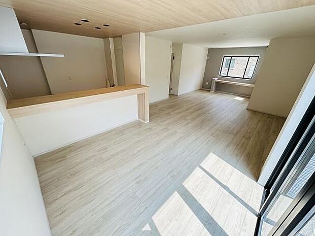 リビングは開放感のある広々とした空間です。大きな窓からたっぷりと自然光が差し込みます。明るいフローリングが全体を爽やかに演出しています。カウンターキッチンがアクセントになっています。