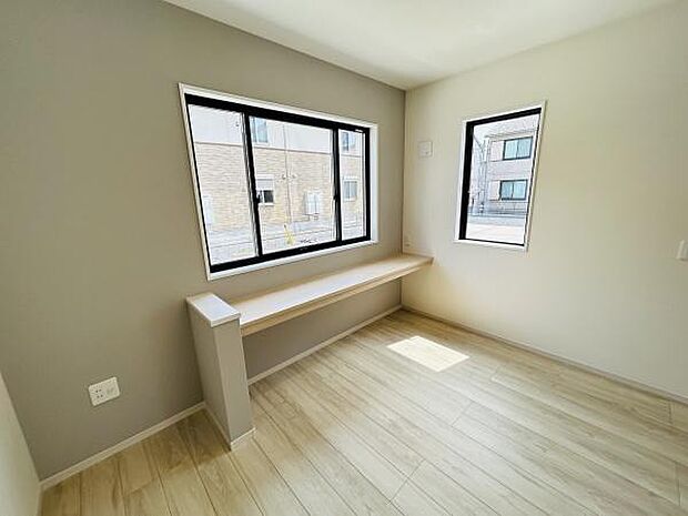 大きな窓から明るい光が差し込むリビングです。シンプルな内装が空間をすっきりと見せます。床材の色合いが温かみを感じさせます。窓辺のカウンターがアクセントになっています。