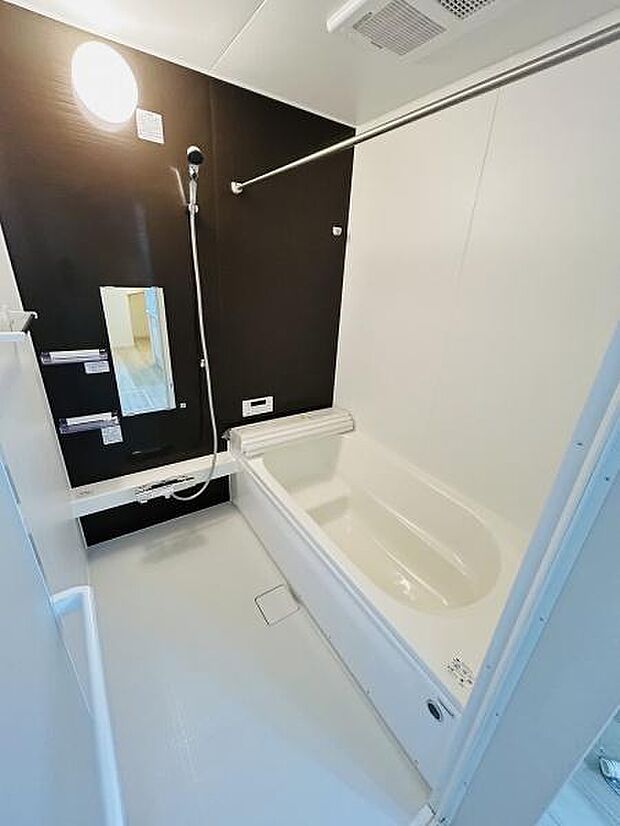 黒と白のコントラストが際立つスタイリッシュなバスルームです。壁に設けられた大きめのミラーとゆったりとした浴槽が魅力です。シャワーと浴槽の両方が使いやすく設計されておりお手入れも簡単な印象です。