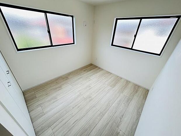 二面に窓があり明るい採光が特徴の寝室です。シンプルな色調のフローリングが空間を広く見せます。収納スペースも配置されています。角部屋のため開放感があります。プライバシー性にも配慮された造りです。