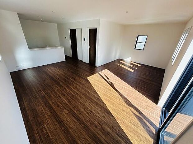 リビングはダークブラウンのフローリングが印象的で上質な雰囲気を演出しています。窓からは光がしっかり入り室内は明るく保たれています。キッチンとの距離も近く使い勝手に配慮された空間です。