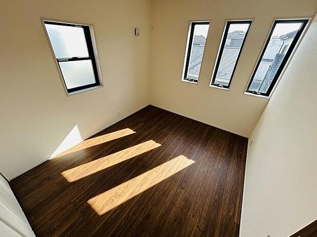 洋室には複数の窓が設けられており自然光が室内にしっかりと差し込みます。すっきりとした壁面やダークカラーのフローリングが特徴です。天井も高くシンプルなデザインで使い勝手の良い空間です。