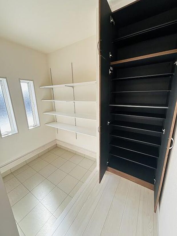 玄関には明るい窓があり自然光が差し込みます。収納スペースが充実しており棚とシューズクローゼットでスッキリした印象です。タイル床とフローリングの切り替えがアクセントになっています。