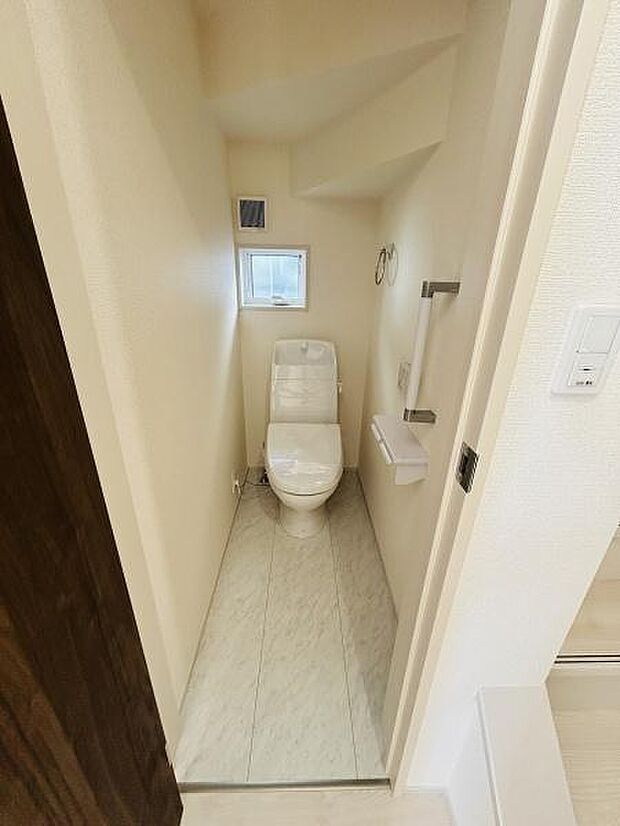 小窓付きで自然な換気が可能なトイレです。手すりが設置されており安心してご利用いただけます。シンプルな内装でお手入れも簡単です。コンパクトな空間ながらも十分な機能性を備えています。