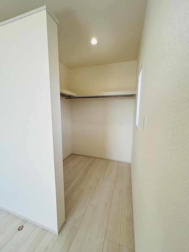 シンプルで使いやすい収納スペースです。棚やハンガーポールが備わっており衣類や小物の整理に便利です。明るい色合いの床材で清潔感があります。室内の一角にあるため日常的にアクセスしやすい設計です。