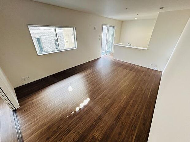 リビングは広々とした空間設計で木目調のフローリングが落ち着いた雰囲気を演出しています。大きな窓からはたっぷりと自然光が差し込み室内が明るく感じられます。