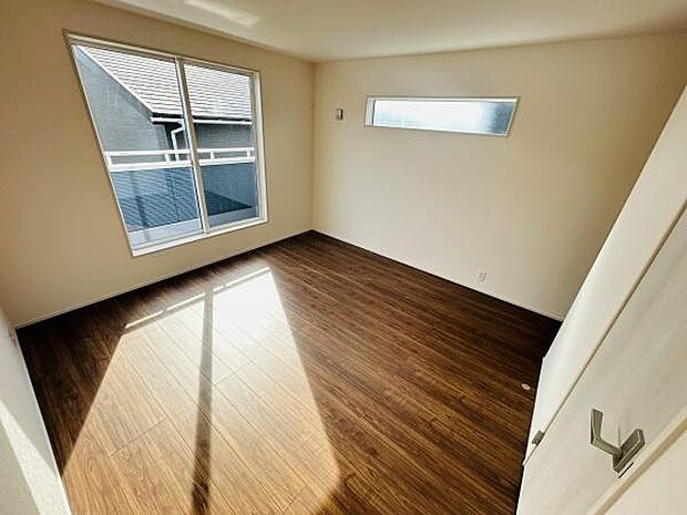 大きな窓からたっぷりと光が差し込む寝室です。落ち着いた色合いのフローリングが特徴的です。収納スペースもあり使い勝手が良いです。天井までの窓が空間に開放感を与えます。