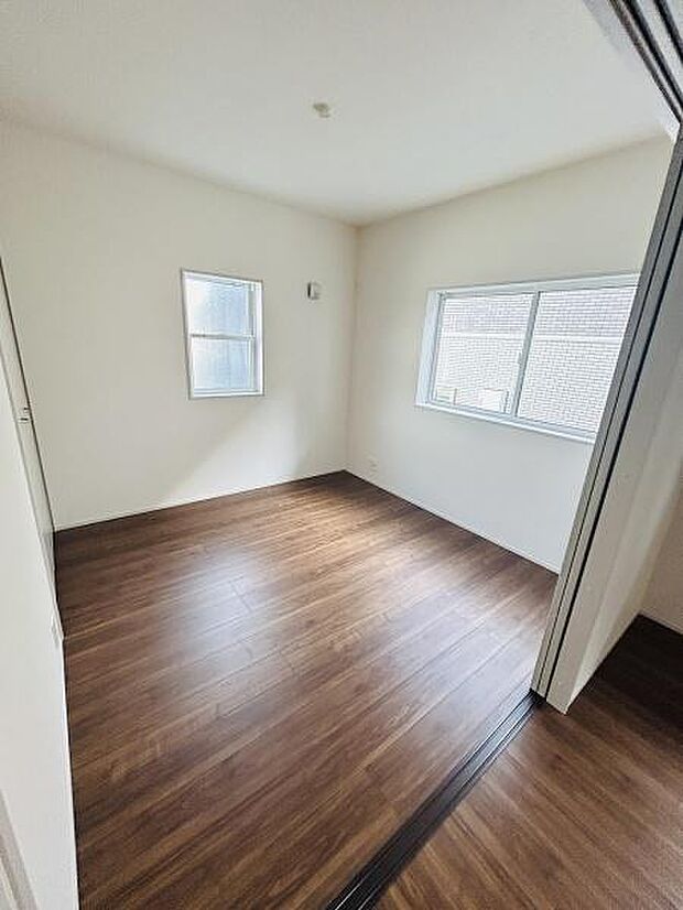 二面採光で室内が明るくなります。シンプルな設計で家具の配置がしやすい洋室です。フローリング仕上げが落ち着いた印象を与えます。引き戸付きで空間を自在に活用できます。清潔感のある内装です。