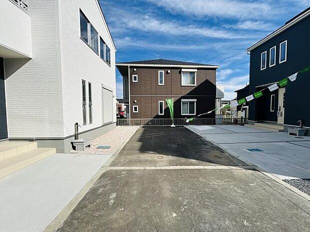 現地写真からは前面道路がしっかり舗装されている様子がわかります。両サイドの建物も新しく整った外観です。敷地内のスペースが広く車の出入りもスムーズに行えます。