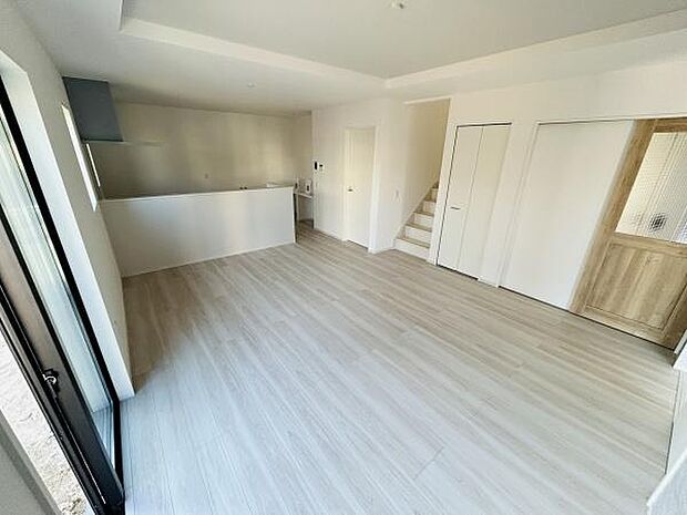 明るい色合いのフローリングが特徴のリビングです。開放的な空間が広がり窓からの採光も十分です。キッチンとのつながりがあり使いやすいレイアウトです。階段が近くにあり移動もスムーズです。