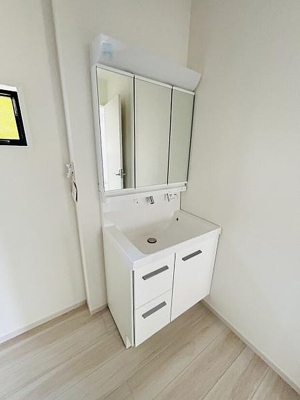 シンプルなデザインが特徴の洗面台です。収納スペースが備え付けられており日用品をすっきりと整理できます。三面鏡仕様で身支度も快適です。清潔感のある配色が印象的です。