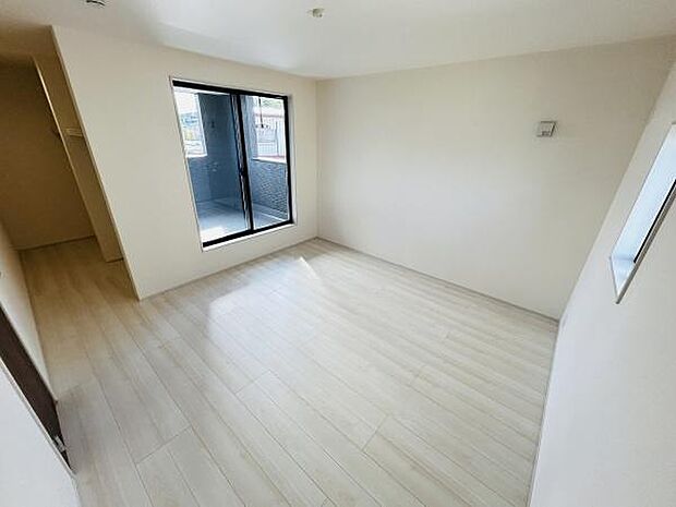 大きな窓から自然光が差し込み明るい寝室になっています。白を基調とした床と壁で広さを感じさせる空間です。清潔感が漂い使いやすいレイアウトが魅力的です。バルコニーへのアクセスも便利です。