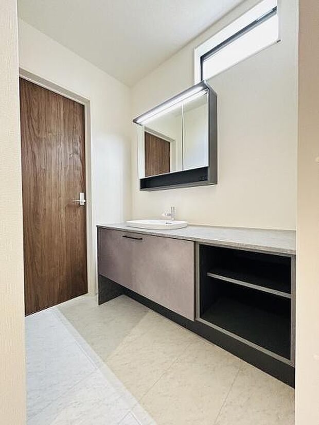 洗面台・洗面所はすっきりとしたデザインで明るい空間が広がっています。上部の窓から自然光が取り込まれ快適な印象です。収納棚が備わっており使い勝手も良好です。ミラー付きで毎日の身支度もスムーズです。