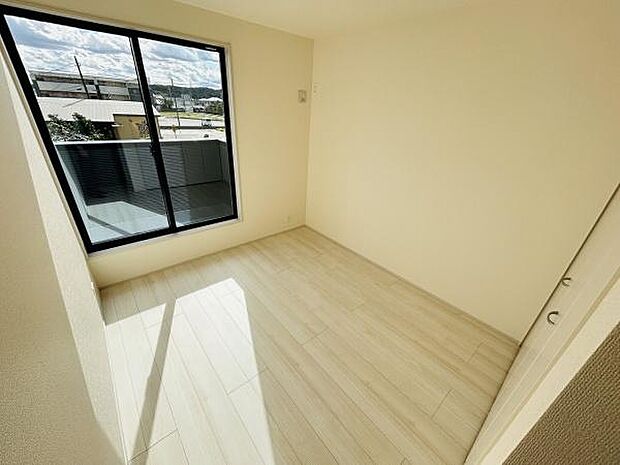 大きな窓からたっぷりと自然光が差し込み明るい印象の洋室です。落ち着いた色合いのフローリングはさまざまなインテリアに合わせやすい仕様となっています。室内がすっきりしており使いやすさが特徴です。
