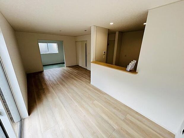 開放感のあるリビングが広がります。明るい床材が室内を爽やかに演出しています。対面キッチンからリビング全体を見渡すことができます。奥には和室も隣接しており便利です。収納スペースも確保されています。