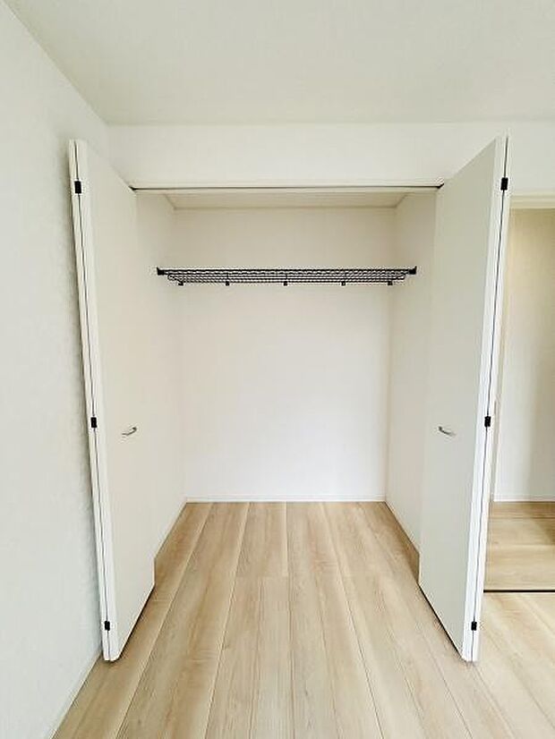ホワイトの建具が清潔感を演出しています。開口部が広く荷物の出し入れがしやすい収納です。パイプハンガー付きで整理整頓しやすい設計となっています。収納スペースがしっかり確保されています。
