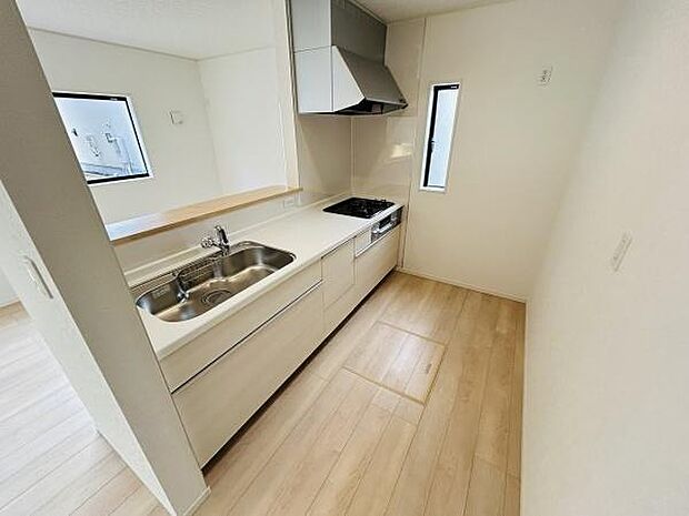 広々としたキッチンは作業効率を重視した設計です。清潔感のあるシンクとコンロが特徴です。換気や採光にも配慮された窓があり明るい印象を与えます。収納スペースも確保されています。
