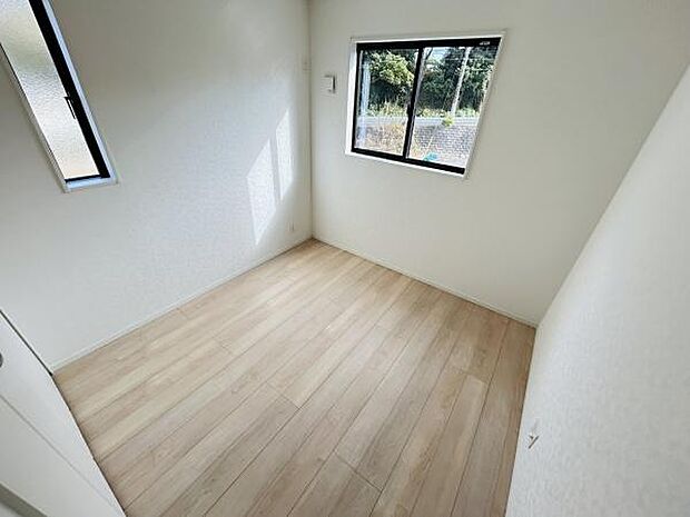 二面採光で室内が明るく感じられます。白を基調とした壁が清潔感を引き立てます。フローリング仕様が特徴的です。シンプルな洋室は自由なレイアウトが可能です。収納スペースも確保されています。