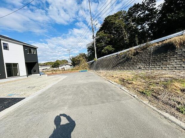 現地の前面道路は広々としており車の出入りもスムーズに行えます。周辺は開放感のある環境が広がっています。道路沿いには緑も多く圧迫感がありません。建物も新しく整った印象が感じられます。