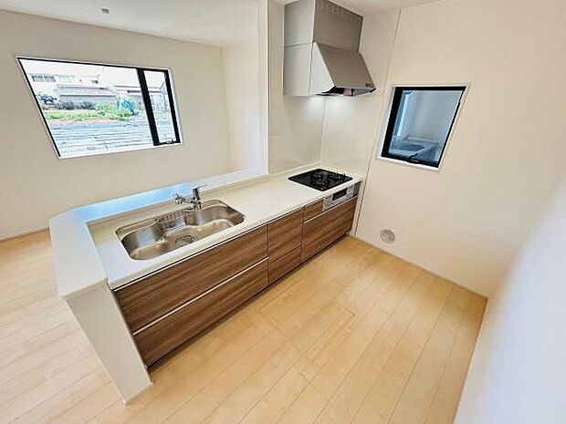 二面採光で明るさが広がるキッチンです。広々とした作業スペースが嬉しいポイントです。収納力のあるカウンター下の引き出しも備わっています。清潔感のあるフローリングとシンク周りが印象的です。
