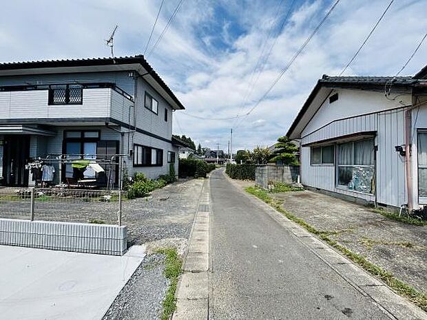 現地写真からは前面道路がしっかりと舗装されている様子が分かります。両側には住宅が立ち並び周囲の環境もよく確認できます。幅も十分にあり車の出入りも対応しやすいです。周辺の雰囲気が伝わる一枚です。
