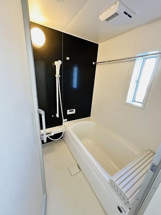 明るい照明と清潔感ある白を基調にしたバスルームです。浴槽と壁のコントラストがシンプルな印象を演出します。浴室乾燥機も備わっており便利です。小窓があり換気もしやすい設計です。