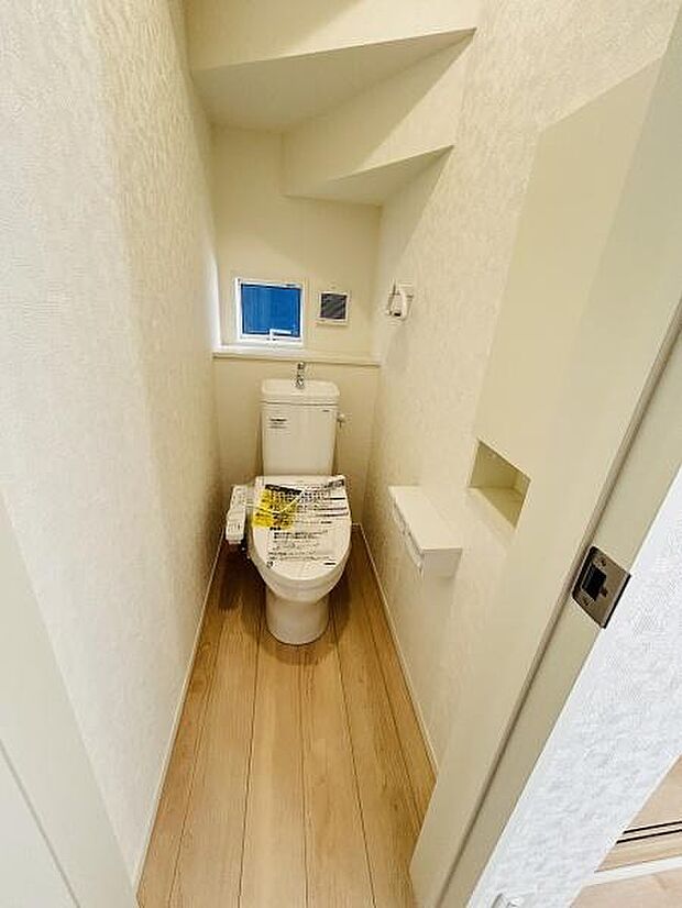 トイレには小窓が設けられており明るい自然光が差し込みます。シンプルな内装が清潔感を感じさせます。限られたスペースを有効活用した設計となっています。床材の風合いが空間にやさしさを与えています。
