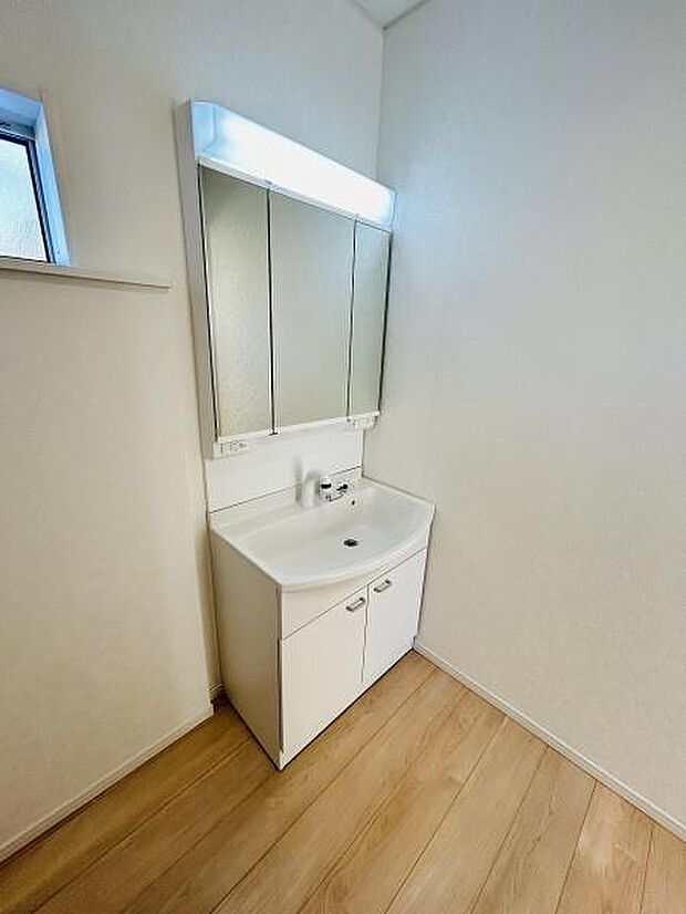 明るい雰囲気の洗面所で清潔感ある空間となっています。収納スペースが確保されておりシンプルなデザインです。鏡面の幅も充分で毎日の身支度に便利です。壁際の小窓からは自然光も取り入れられます。