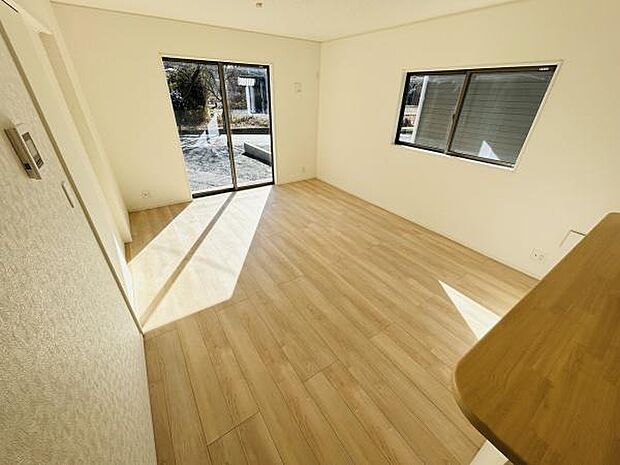 明るい陽射しが差し込むリビングです。窓が大きく室内が開放的に感じられます。白を基調とした内装が空間をすっきり見せます。フローリングの質感が優しい印象を与えます。