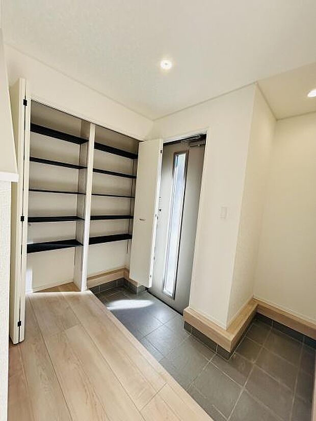 玄関横に設けられた収納スペースは奥行きがあり多用途に利用できます。可動式の棚なので高さの調整が可能です。扉付きで見た目もすっきりとしています。日常使いに便利な収納です。整理整頓もサポートします。