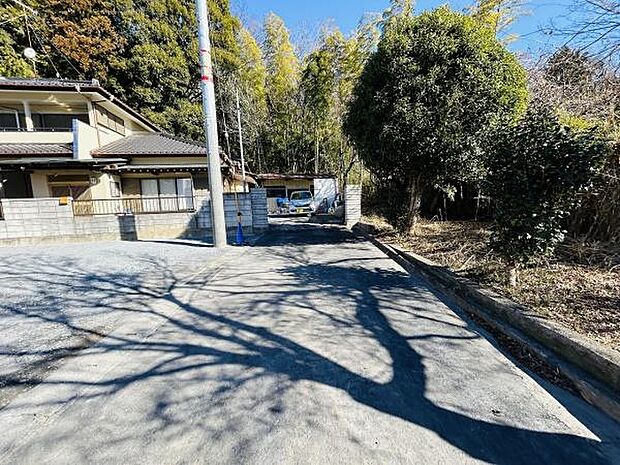 前面道路が広々としており車の出入りもスムーズに行えます。周辺には緑が多く静かな環境が魅力です。日当たりも良好で開放感のある現地写真です。隣接する住居との距離感も十分に確保されています。