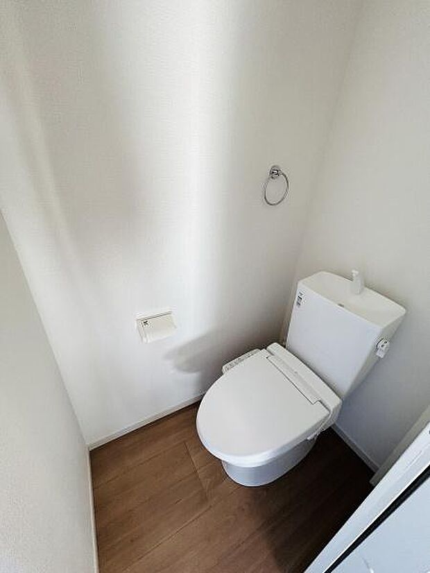 清潔感のあるシンプルなトイレ空間です。壁や床のカラーが落ち着いた印象を与えます。収納や設備がすっきりとまとまっています。余分な装飾がなく使いやすさを重視した設計です。