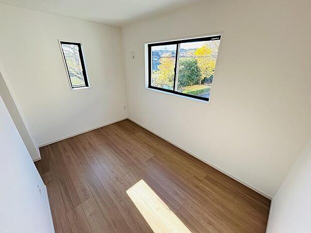 二面採光の洋室は明るい印象となっております。白を基調とした壁で開放感を感じられます。窓からの景色も魅力的なポイントです。木目調の床が落ち着いた雰囲気を演出しています。お手入れもしやすい洋室です。