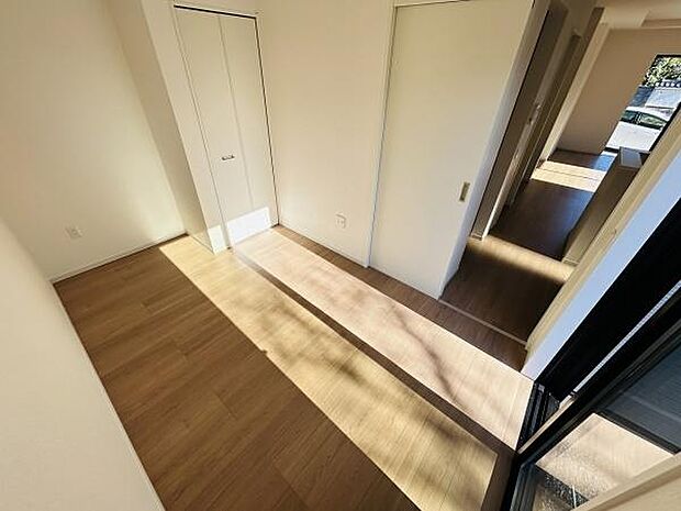 大きな窓からたっぷりと光が差し込む洋室です。明るいフローリングが室内を広く見せています。シンプルなデザインで家具の配置もしやすい空間です。収納スペースも備わっているためお部屋をすっきり保てます。