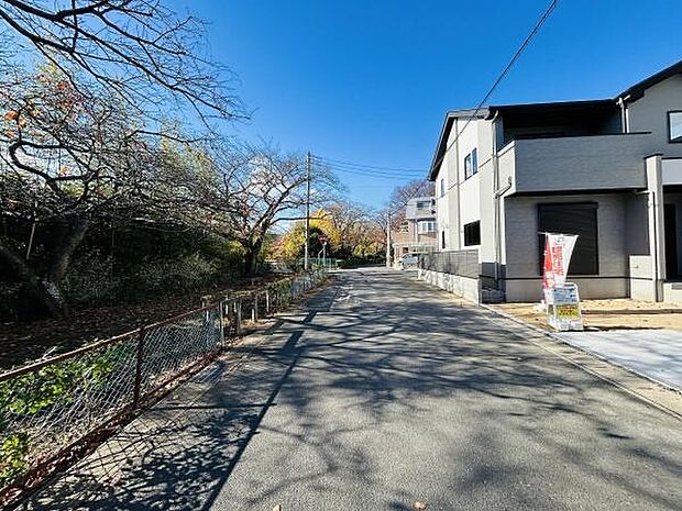 前面道路はゆったりとした幅があり周囲には自然を感じられる緑も広がっています。建物はシンプルで落ち着いた外観となっております。道路からの見通しも良好です。周辺環境が整っている現地写真です。