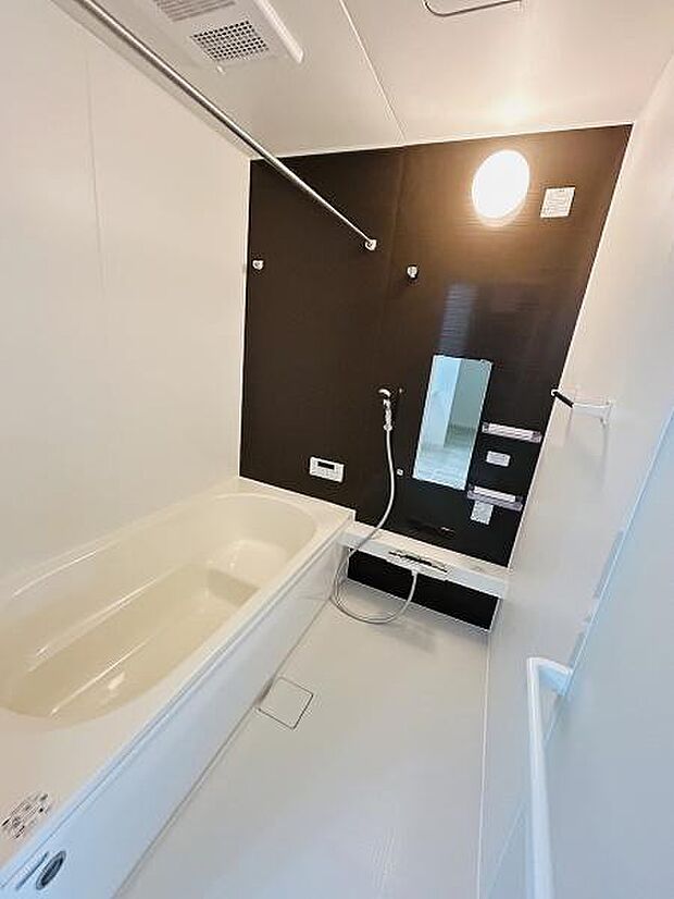 浴室内は明るい色合いとダークトーンのアクセントパネルで洗練された雰囲気です。広々としたバスタブが設置され足を伸ばしてゆっくりと入浴できます。