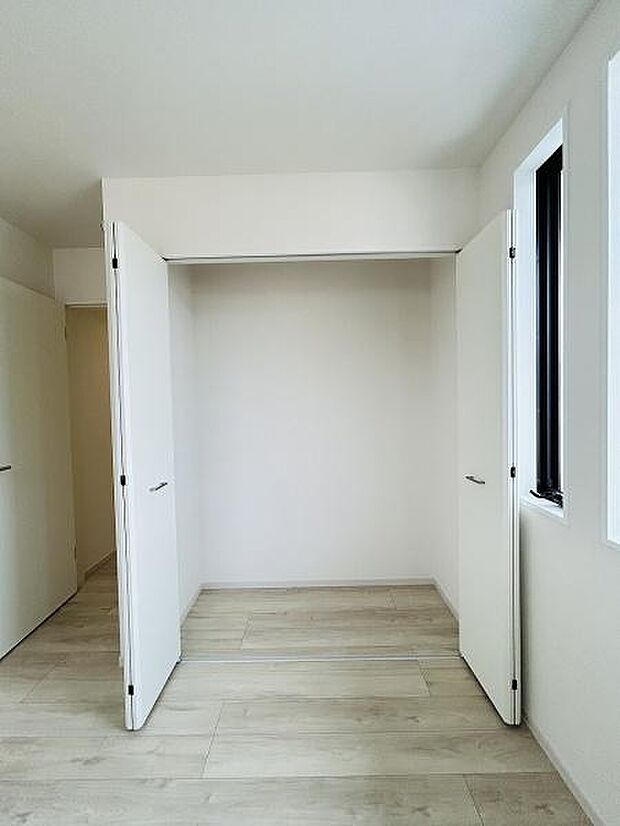 シンプルなデザインの収納スペースです。両開き扉で物の出し入れがしやすい仕様となっています。床と壁の色合いが統一されていて室内に自然に馴染みます。窓が近くにあり明るい印象も感じられます。